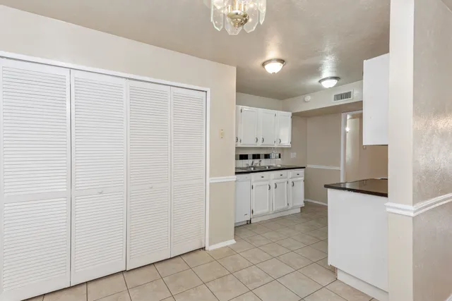 a kitchen with white cabinets and white appliances