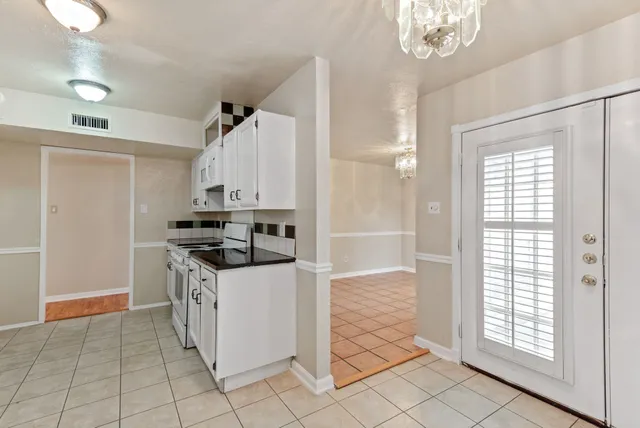 a kitchen with granite countertop a stove and a refrigerator