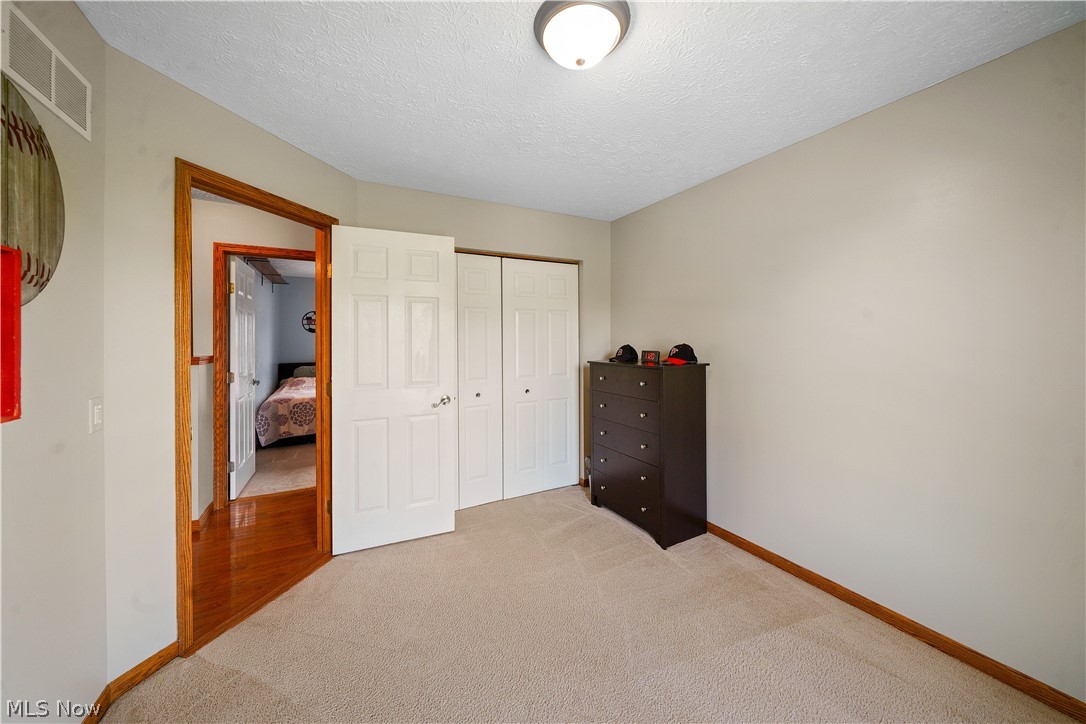 4849 Edson Road Kent, OH 44240 - Photo 29 of 50 Bedroom with a closet, a textured ceiling, and hardwood / wood-style floors
