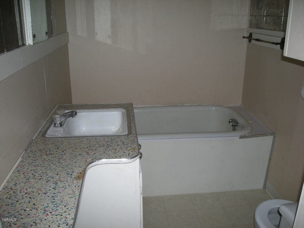 5312 Gamache Road Moxee, WA 98936 - Photo 12 of 15 a bathroom with a granite countertop sink a toilet and tub