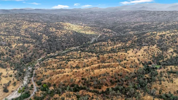 an aerial view of house with yard and mountain view in back