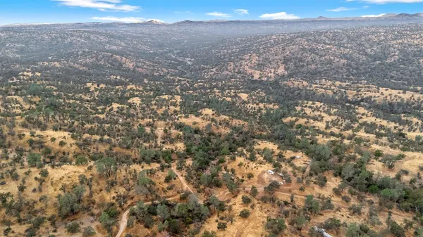 an aerial view of house with yard and mountain view in back