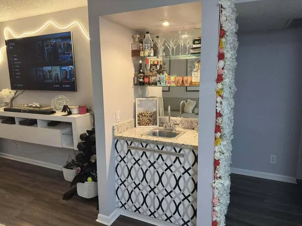 a kitchen with a sink and a stove with wooden floor
