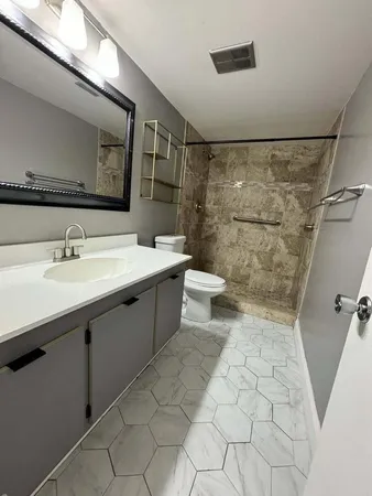 a bathroom with a sink a toilet and shower