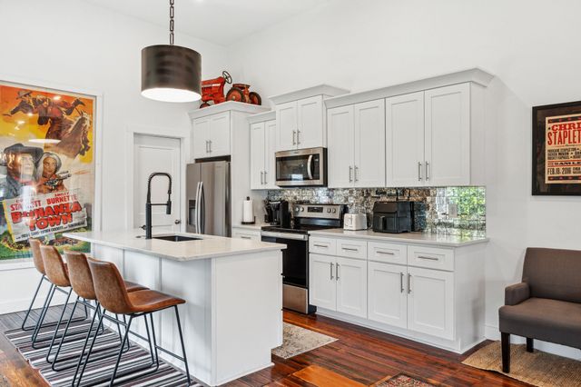 a kitchen with stainless steel appliances a stove a sink and a refrigerator