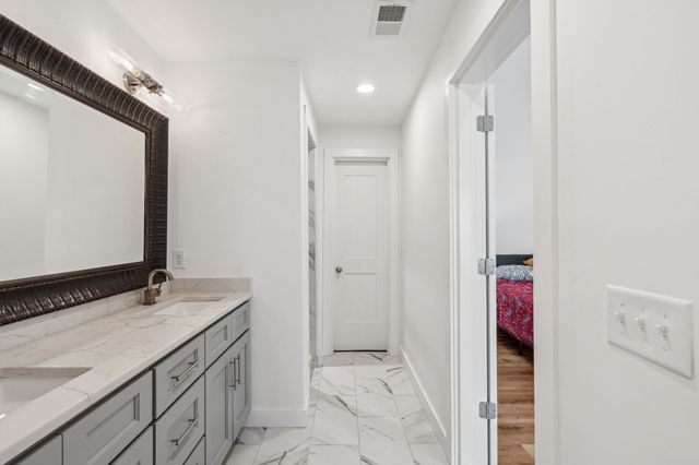 a view of a white house with a small yard and plants