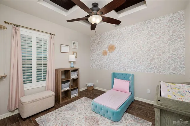 a bedroom with a bed lamp on desk and a window