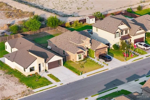 an aerial view of residential houses with yard