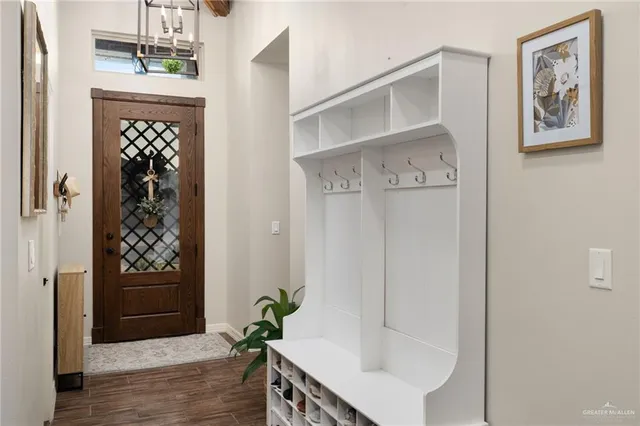 a hallway with painting on the wall and a potted plant