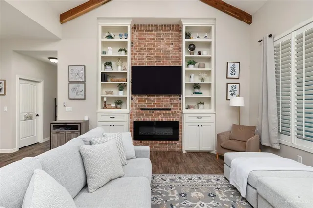 a living room with furniture a flat screen tv and a fireplace