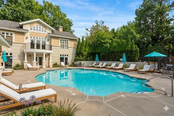 a view of a house with swimming pool and sitting area