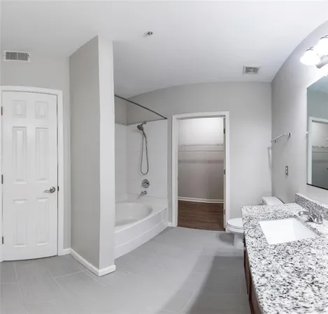 a bathroom with a granite countertop sink a shower and a mirror
