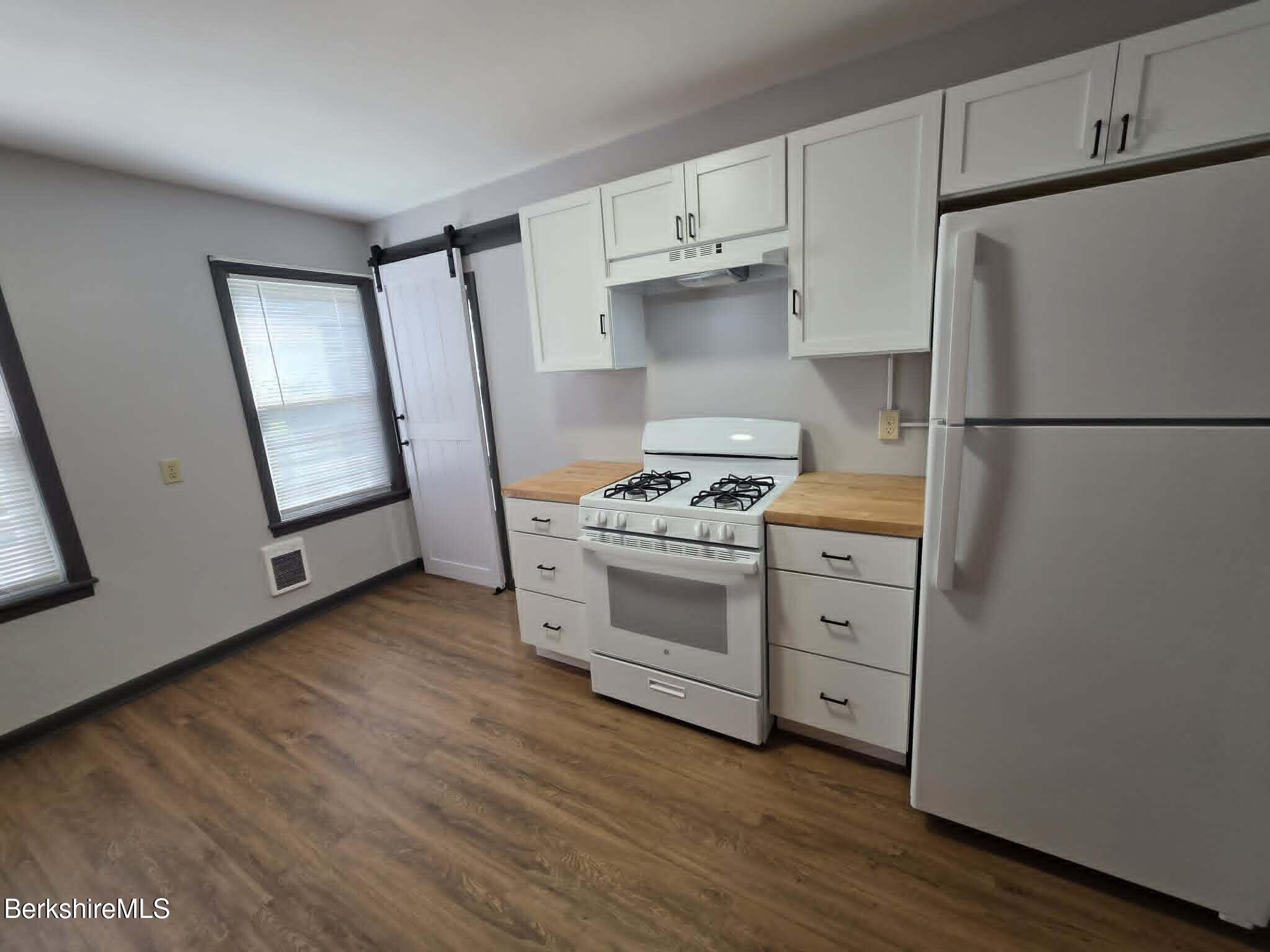 40 East Jordan Street, Unit 1 Adams, MA 01220 - Photo 3 of 12 a kitchen with white cabinets and white appliances