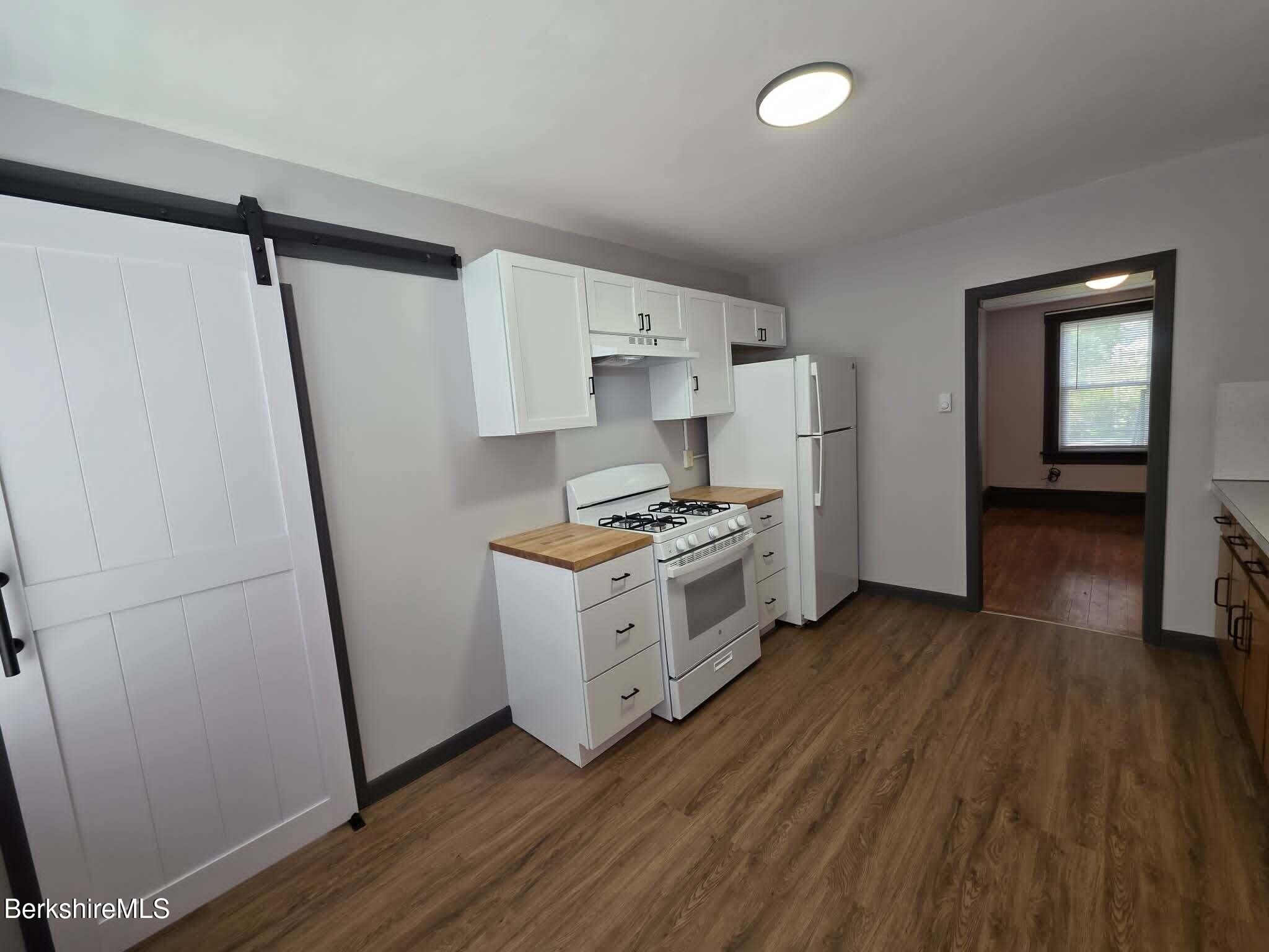 40 East Jordan Street, Unit 1 Adams, MA 01220 - Photo 4 of 12 a kitchen with wooden floors and white appliances