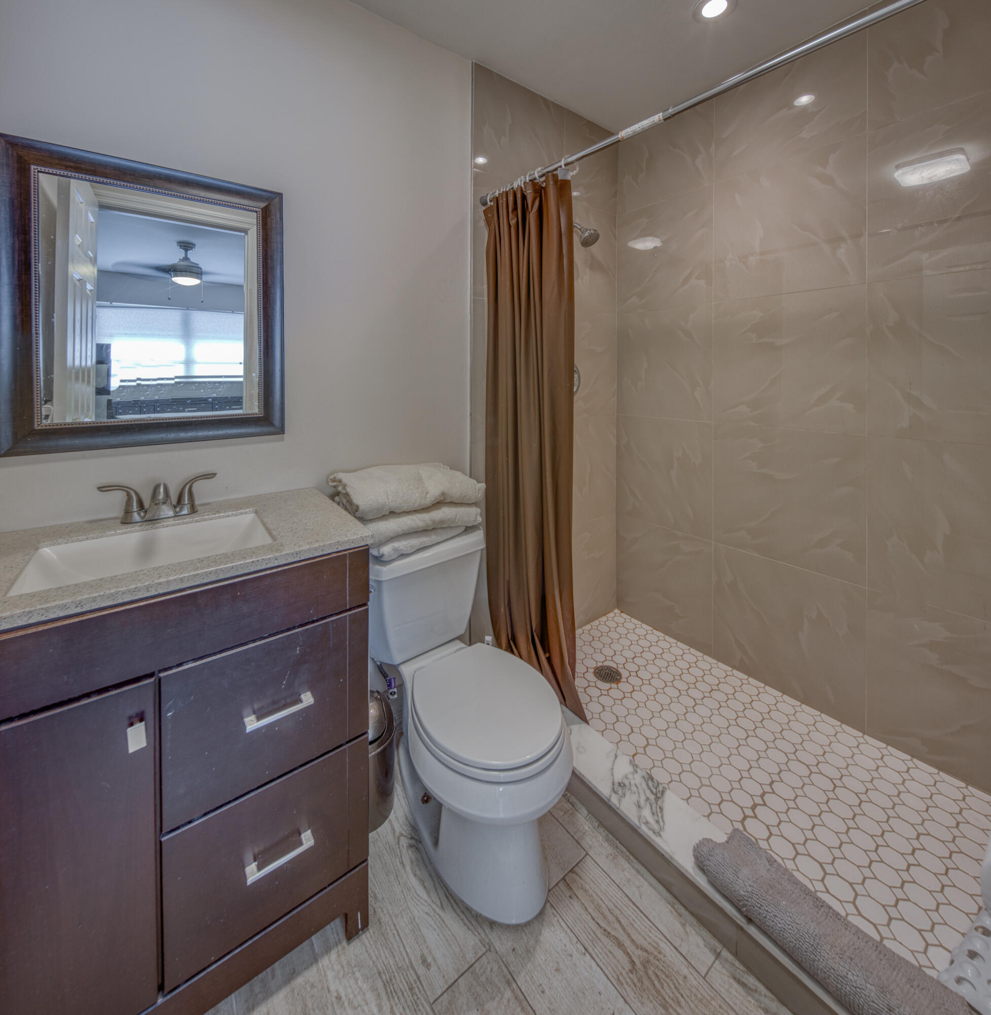 301 South Lakeside Drive, Unit 7 Lake Worth Beach, FL 33460 - Photo 11 of 15 a bathroom with a granite countertop toilet sink and mirror