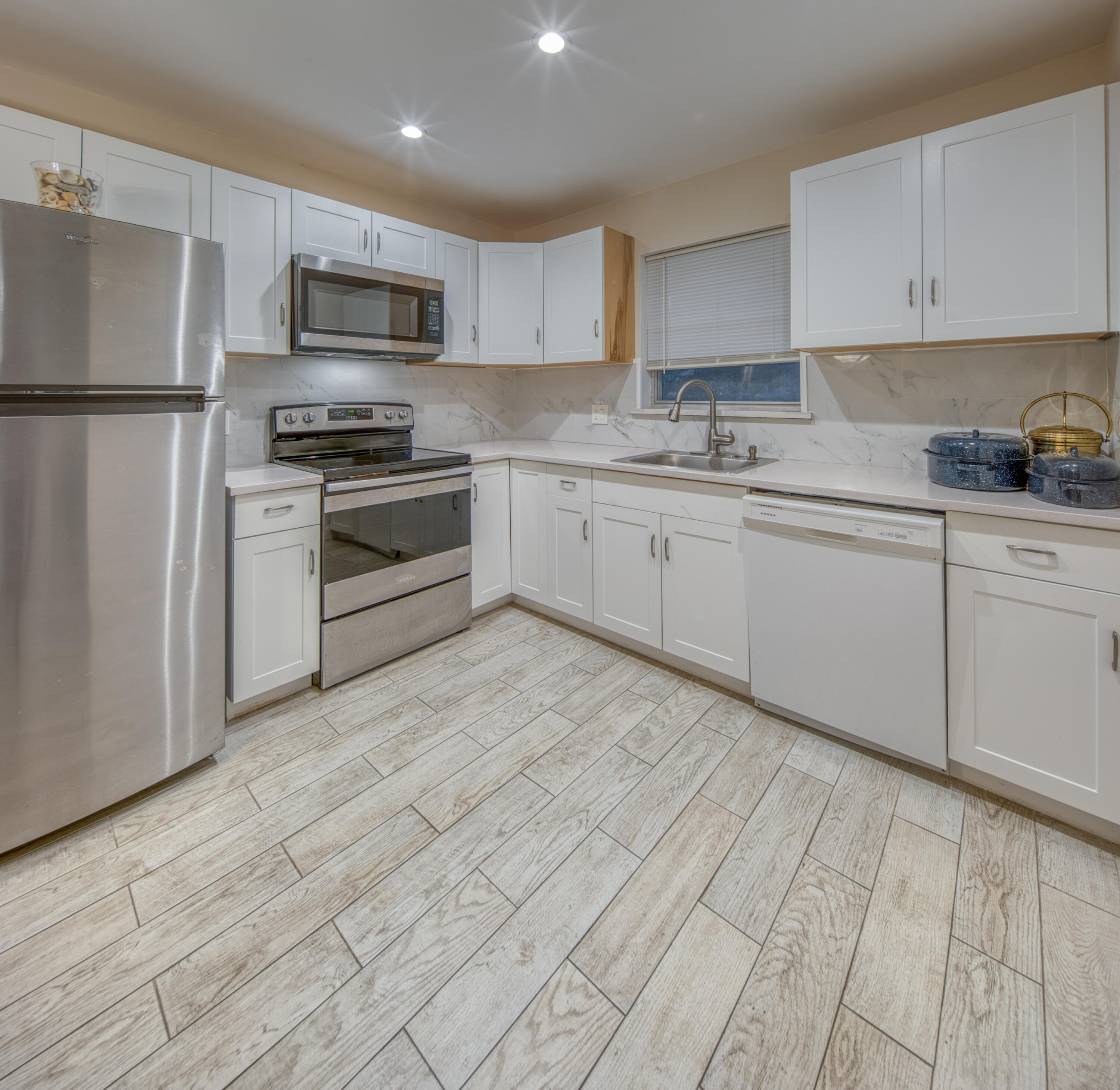 301 South Lakeside Drive, Unit 7 Lake Worth Beach, FL 33460 - Photo 4 of 15 a kitchen with stainless steel appliances granite countertop a stove a sink and a refrigerator