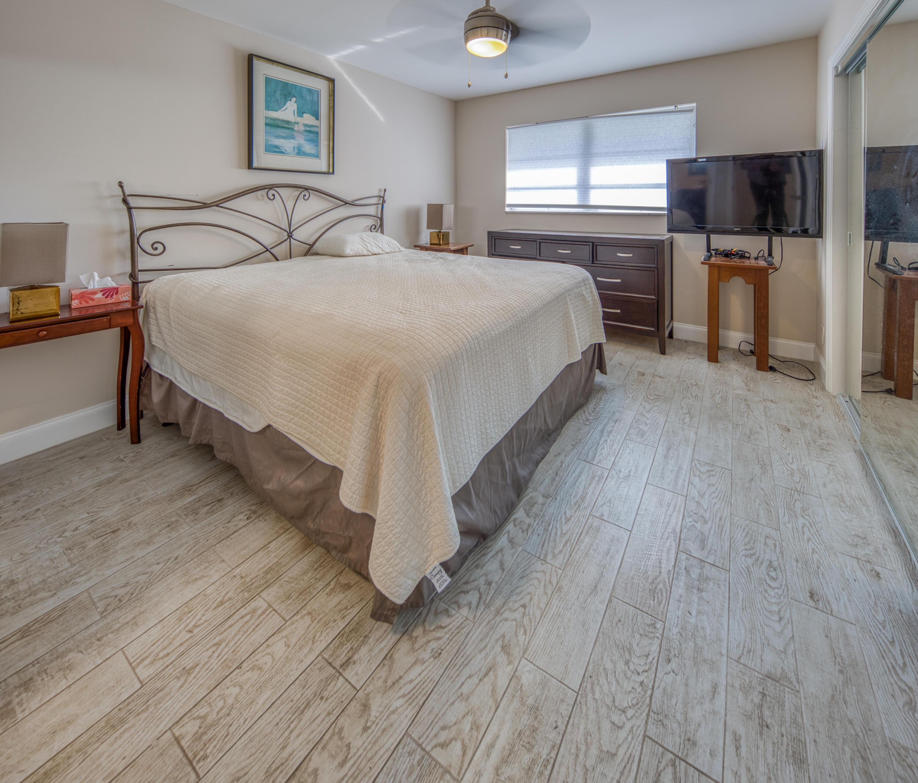 301 South Lakeside Drive, Unit 7 Lake Worth Beach, FL 33460 - Photo 9 of 15 a spacious bedroom with a bed and a television in it