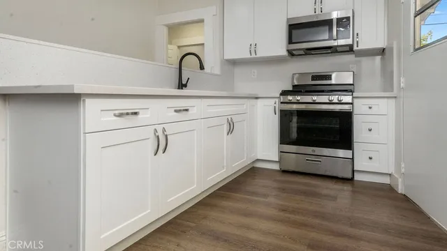 a kitchen with stainless steel appliances a stove microwave and sink
