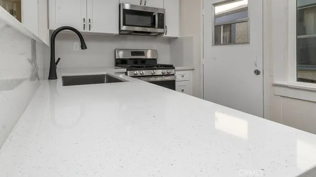 a kitchen with stainless steel appliances a microwave a sink and a stove