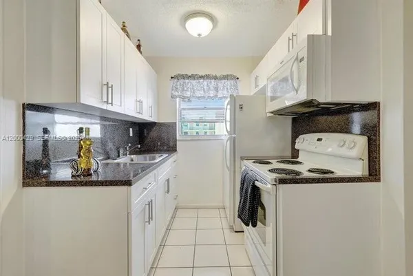 a kitchen with stainless steel appliances granite countertop a sink and a stove