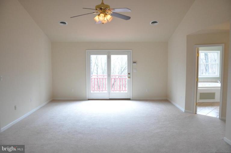 13925 Sunnybrook Road Phoenix, MD 21131 - Photo 19 of 30 an empty room with windows and chandelier fan