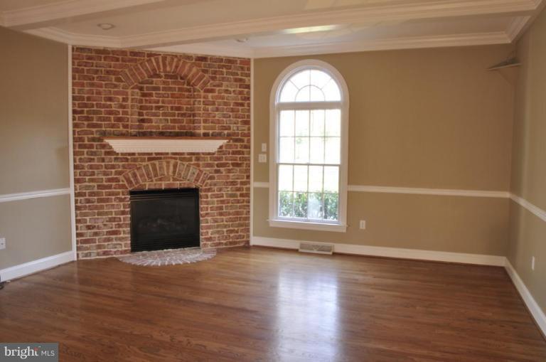 13925 Sunnybrook Road Phoenix, MD 21131 - Photo 10 of 30 an empty room with wooden floor a fireplace and windows