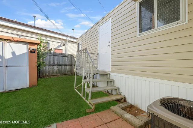 a view of a chair and table in backyard of the house