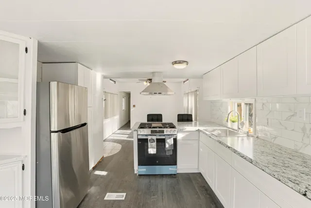 a kitchen with stainless steel appliances granite countertop a refrigerator stove and sink