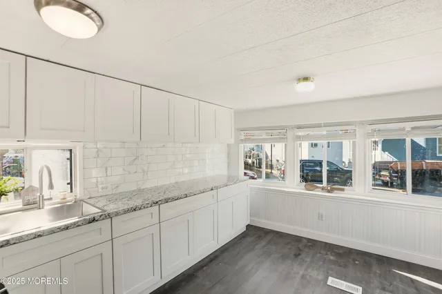 a large white kitchen with a sink and dish washer