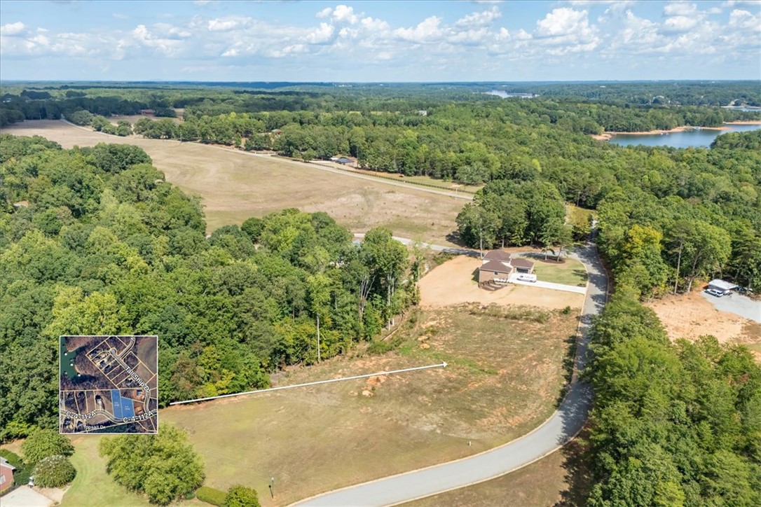 106 C-4-112A Anderson, SC 29625 - Photo 18 of 20 This elevated view captures the expansive lot, bordered by lush trees and a winding road, with distant water.