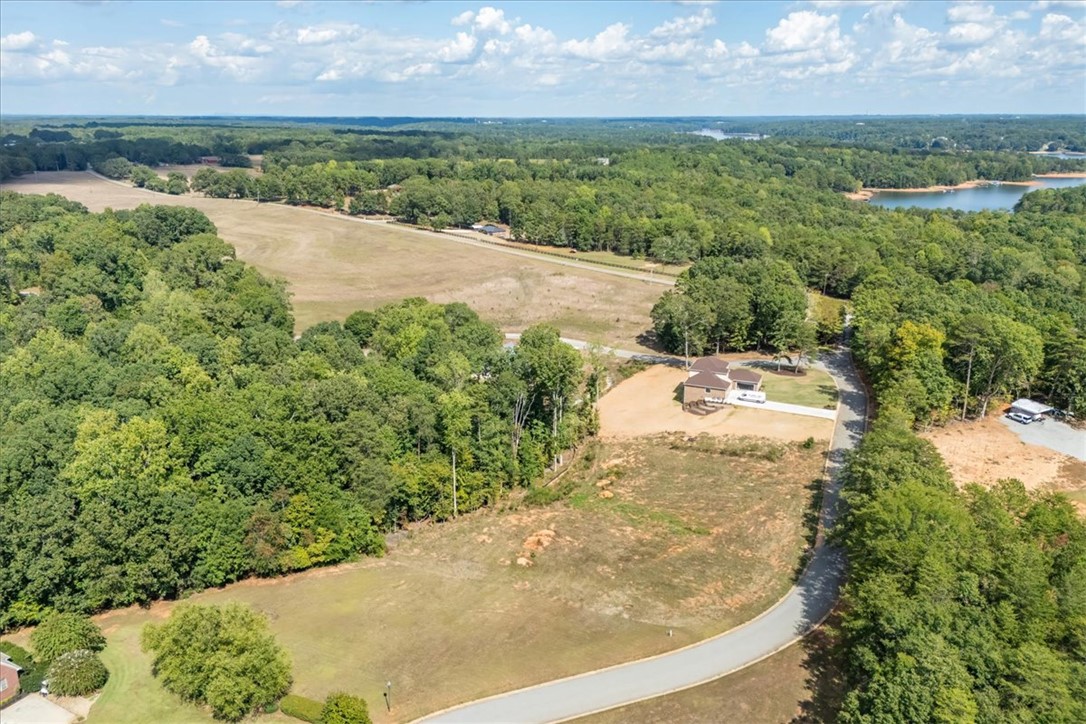 106 C-4-112A Anderson, SC 29625 - Photo 6 of 20 This aerial view showcases a residential lot surrounded by verdant landscapes and distant water.