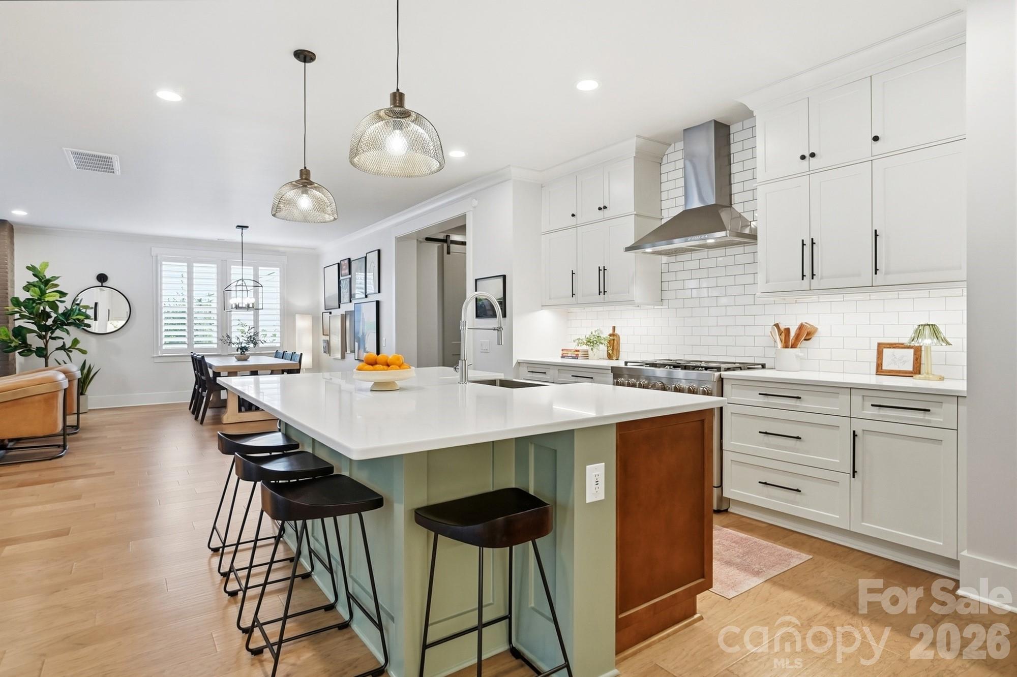 2052 Thatcher Way Fort Mill, SC 29715 - Photo 12 of 47 a kitchen with stainless steel appliances kitchen island granite countertop a table chairs in it and wooden floors