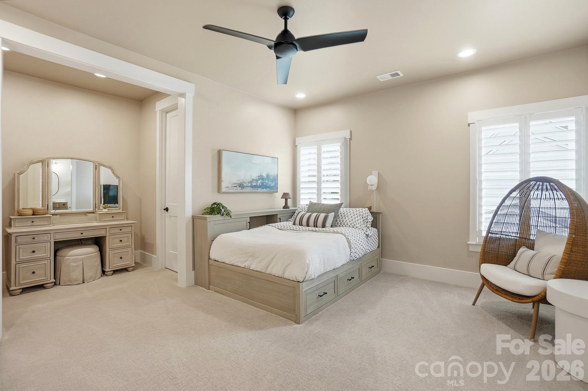 2052 Thatcher Way Fort Mill, SC 29715 - Photo 37 of 47 a spacious bedroom with a bed a chandelier and a couch