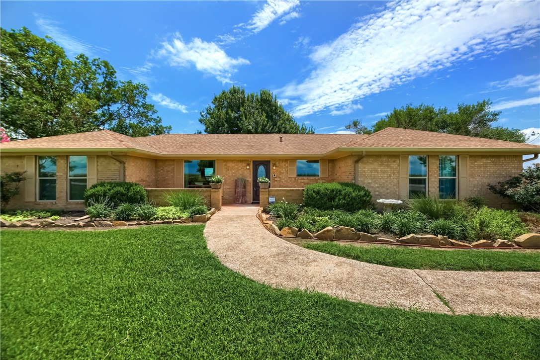 a view of a white house with a yard table and chairs
