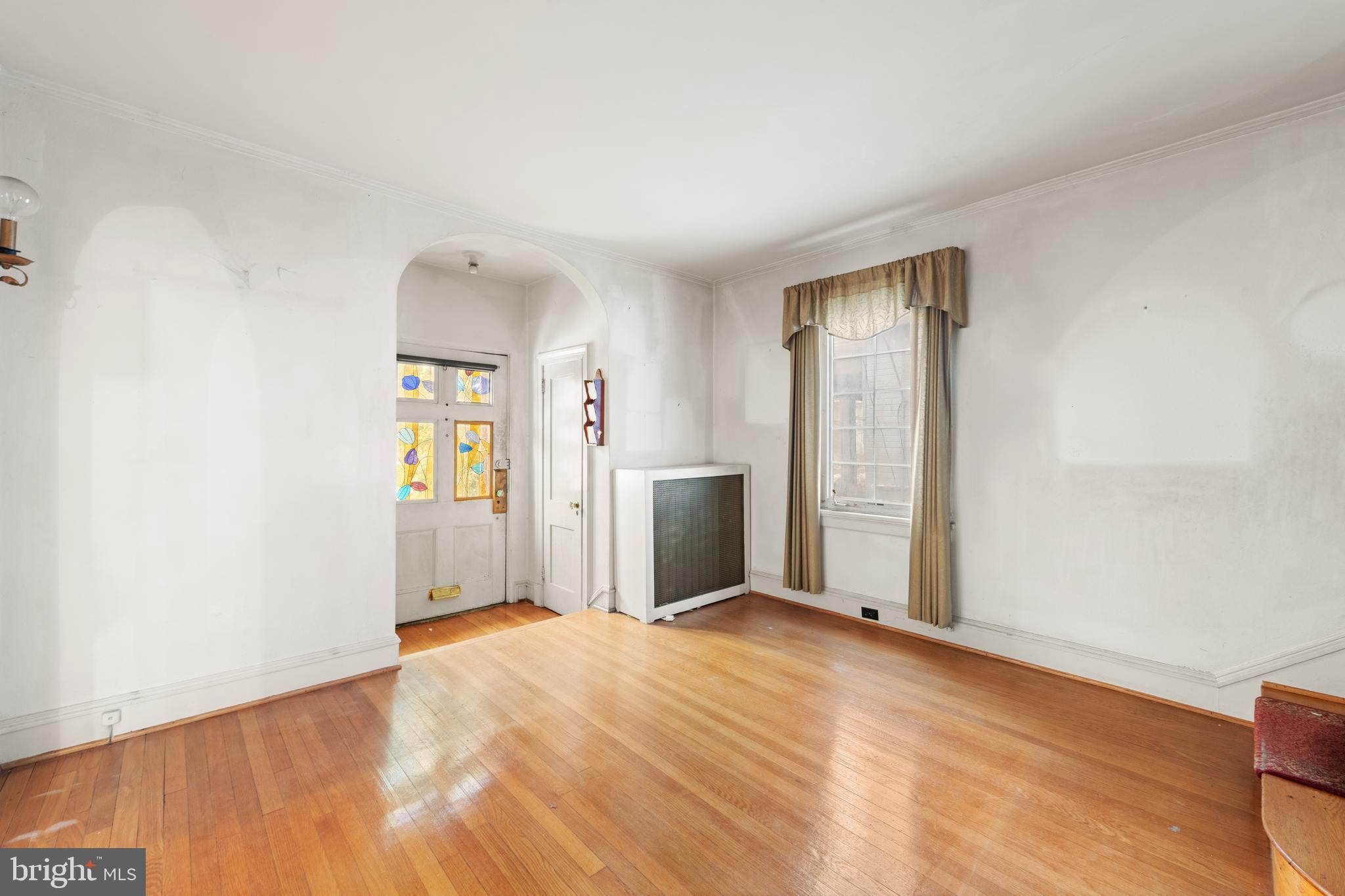 1702 Webster Street Northwest Washington, DC 20011 - Photo 5 of 42 a view of an empty room with wooden floor and a window