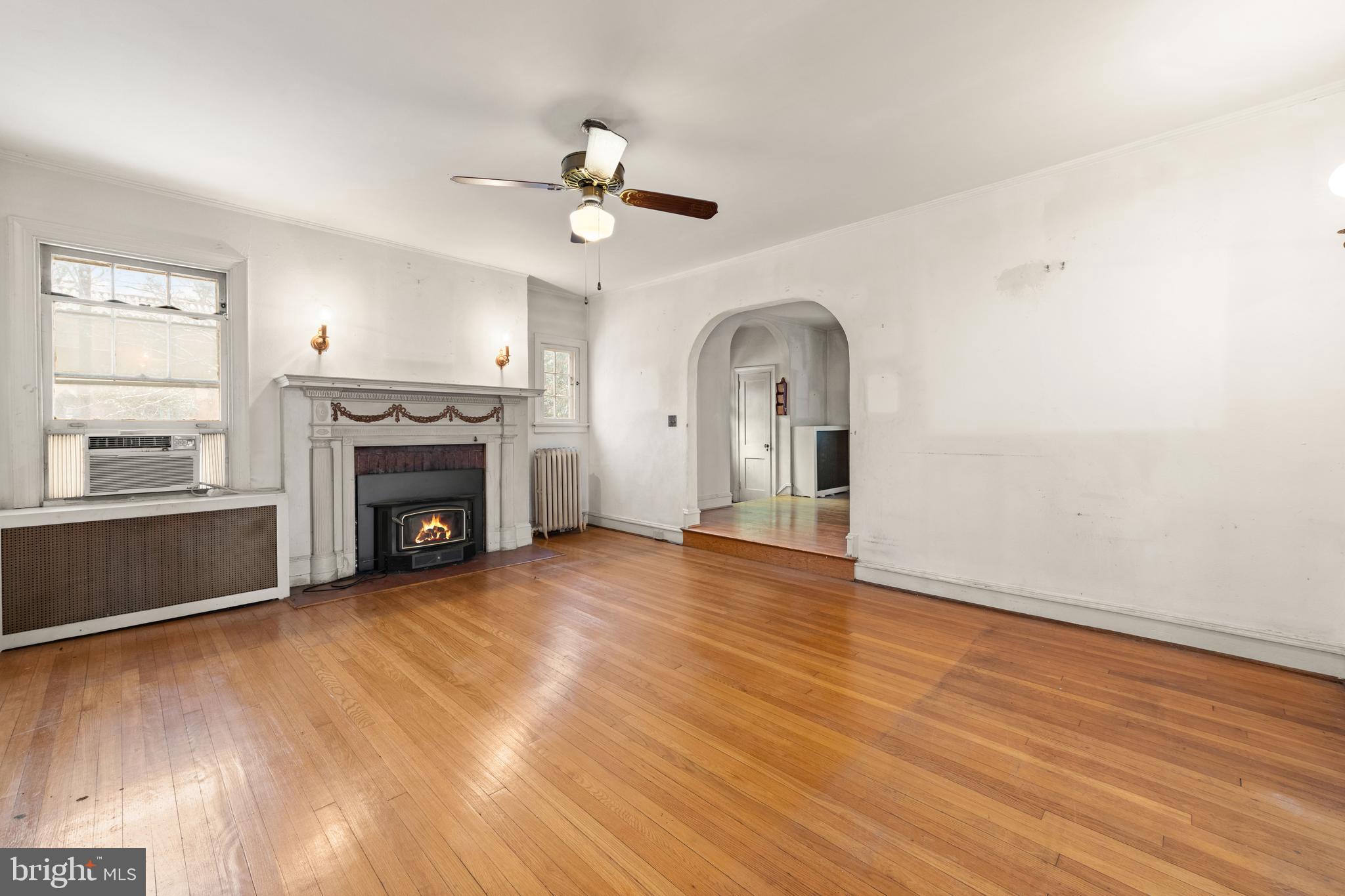 1702 Webster Street Northwest Washington, DC 20011 - Photo 8 of 42 an empty room with wooden floor fireplace and windows
