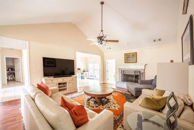 a living room with furniture a flat screen tv and a fireplace