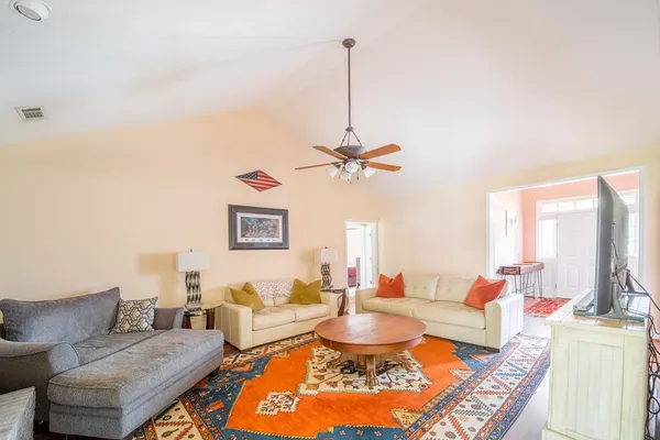 a living room with furniture a rug and a lamp