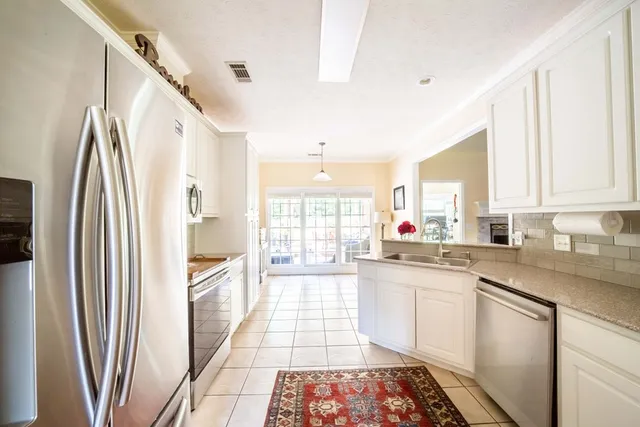 a kitchen with stainless steel appliances a refrigerator sink and cabinets