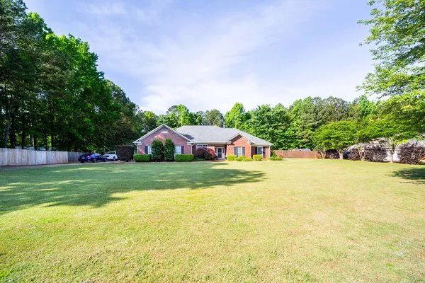 a front view of a house with a yard and trees