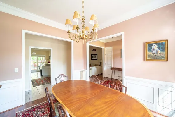 a bedroom with a large bed a chandelier and dresser