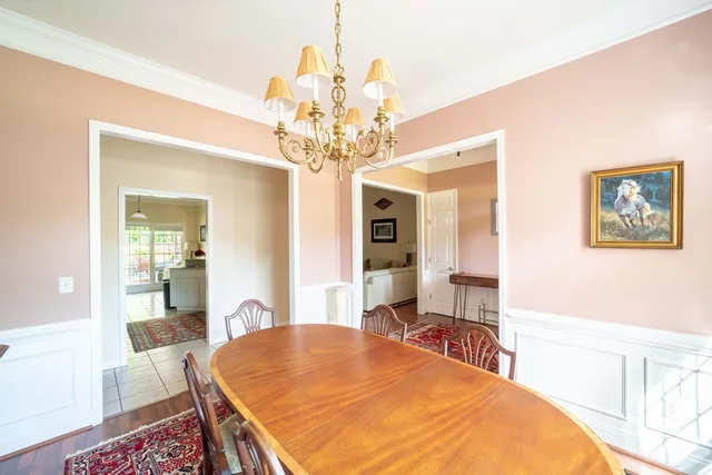 a bedroom with a large bed a chandelier and dresser