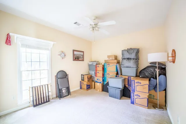 a bedroom with furniture and a fan