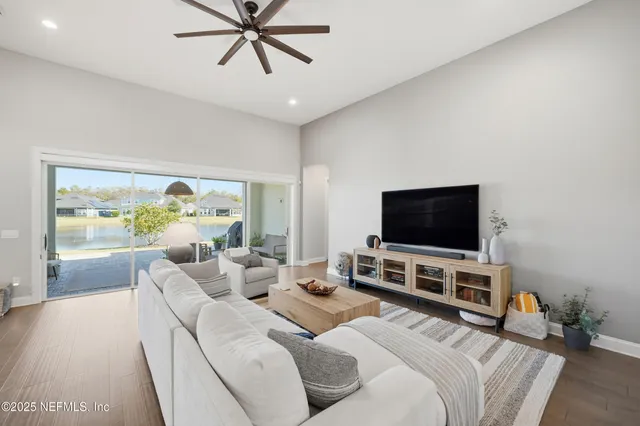 a living room with furniture flat screen tv and a large window