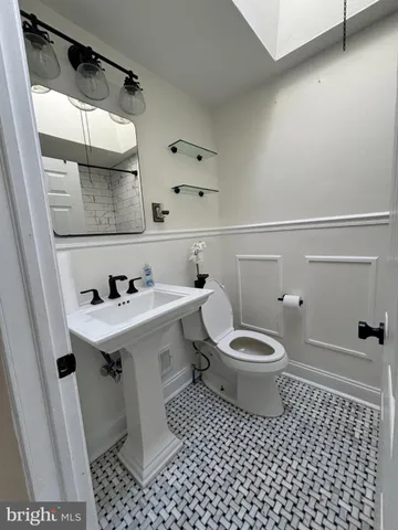 a bathroom with a sink a toilet and mirror