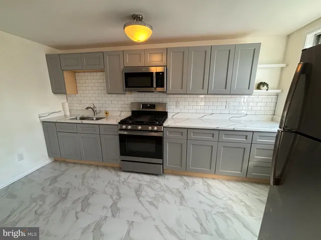 a kitchen with stainless steel appliances a stove sink and microwave
