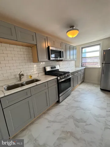 a kitchen with stainless steel appliances granite countertop a sink and a stove
