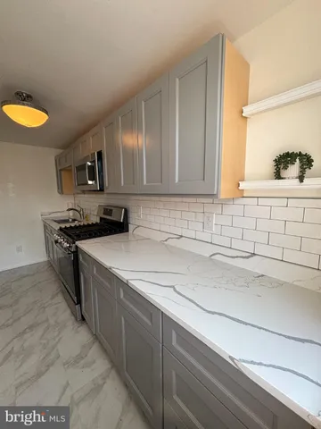 a kitchen with stainless steel appliances granite countertop a sink and a stove
