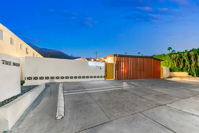 a kitchen that has a lot of white cabinets and stainless steel appliances
