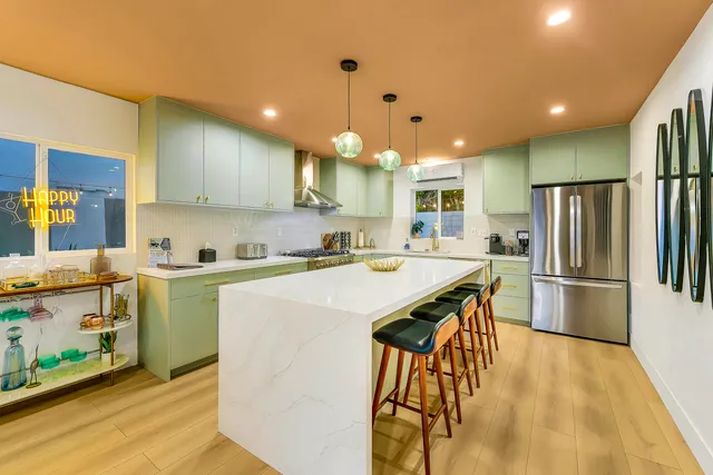 a living room with furniture a rug and a view of kitchen